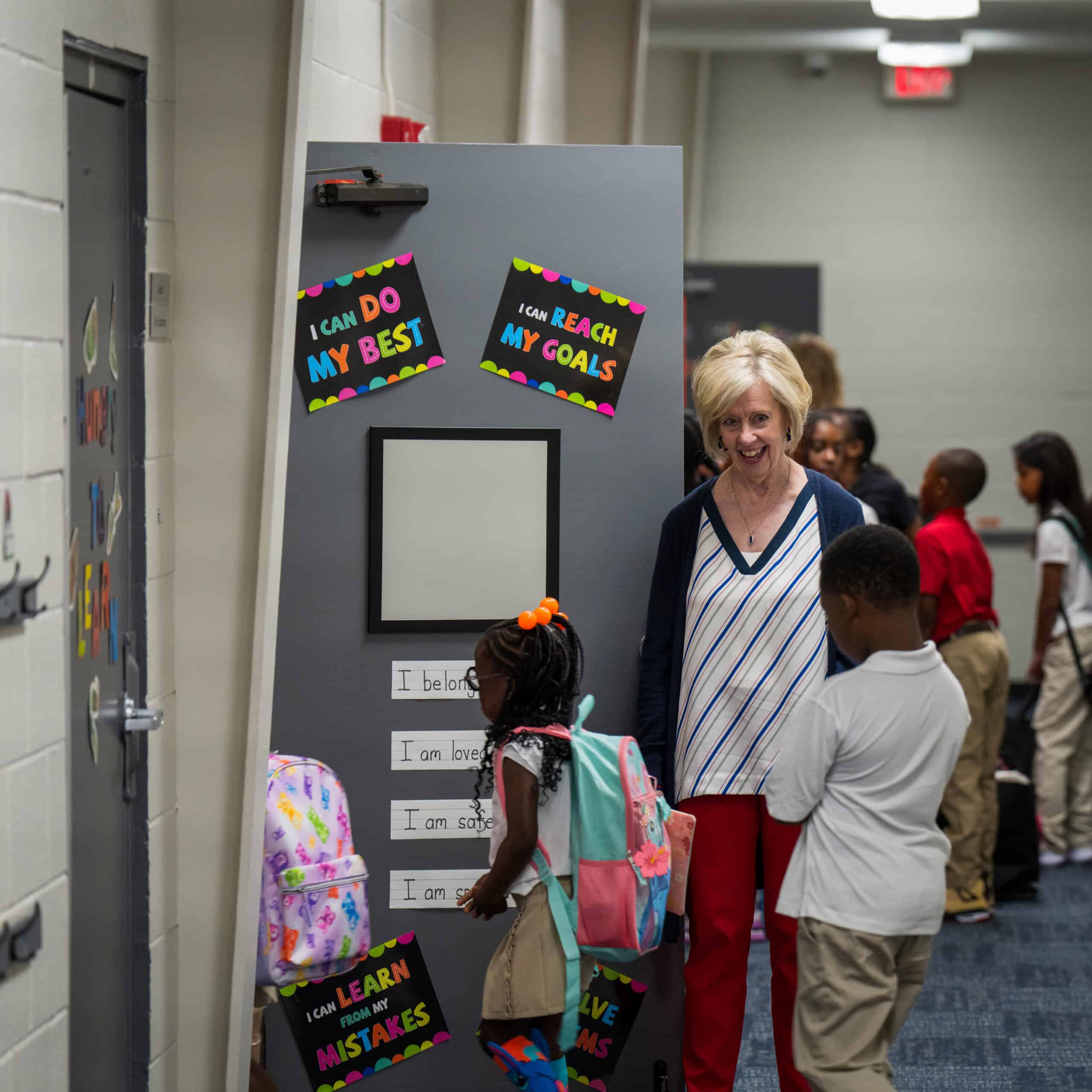 Teacher and students in the hallway with motivational signs